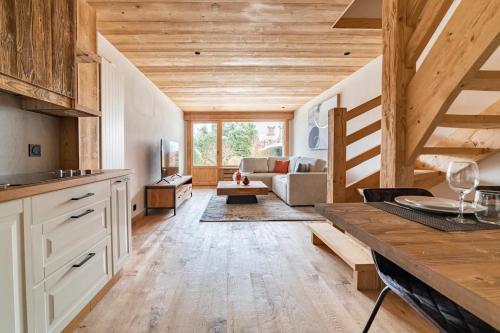 cocina con techos de madera y sala de estar. en Cocon au pied des pistes de ski du Mont-d'Arbois, en Megève