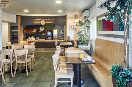 a restaurant with wooden tables and chairs at B&B HOTEL Orly Chevilly-Larue - Nationale 7 in Chevilly-Larue