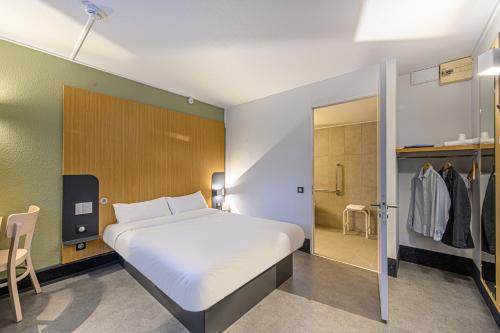 a bedroom with a large bed and a walk in shower at B&B HOTEL Vannes Est Golfe du Morbihan in Vannes