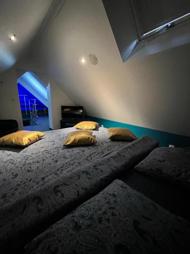 a bedroom with two large beds with yellow pillows at Le Wellness Privatif in Seraing