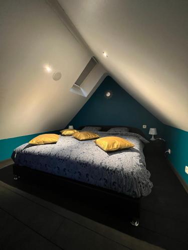 a bedroom with a bed with yellow pillows on it at Le Wellness Privatif in Seraing
