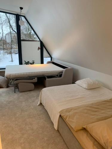 a bedroom with two beds and a table and a window at Vallikraavi Penthouse in Tartu