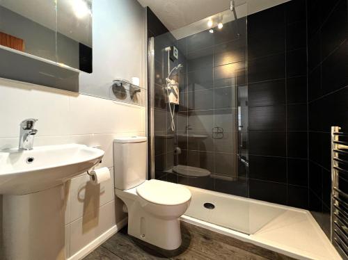 a bathroom with a toilet and a sink and a shower at Brunswick Court in Cowes