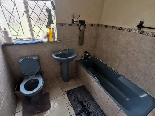 a bathroom with a tub and a toilet and a sink at House n Car in Krugersdorp