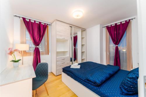 a bedroom with a blue bed and a desk at Central 700 square Fructus plaza - Eva apartment in Timişoara