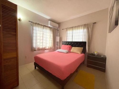 1 dormitorio con cama con sábanas rosas y ventana en Amazing 2 bedroom apt 1 warm cosy comfortable en Belmont