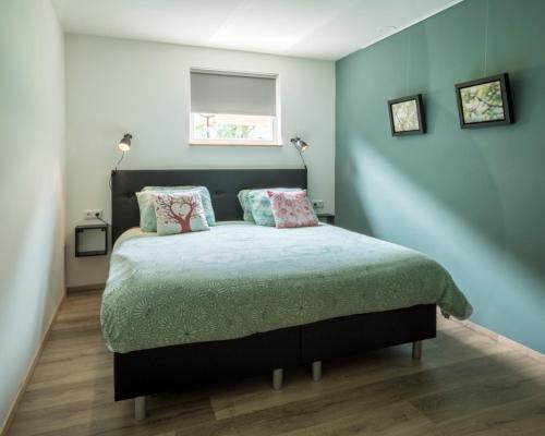 1 dormitorio con cama con almohadas y ventana en In de 7e Hemel, en Grashoek