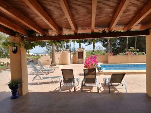 a patio with chairs and a swimming pool at Villa Parra in Benissa