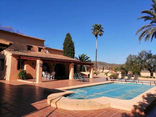 a house with a swimming pool and a palm tree at Villa Parra in Benissa