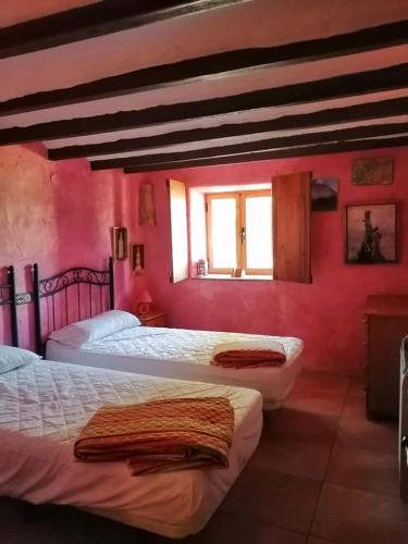 two beds in a room with pink walls at Villa Parra in Benissa