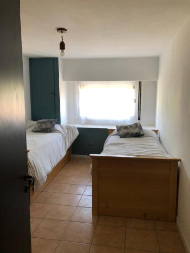 a small bedroom with two beds and a window at Dpto Pque in Azul