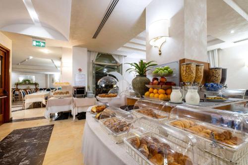 uma linha de buffet com muitos tipos diferentes de alimentos em Quality Hotel Nova Domus em Roma