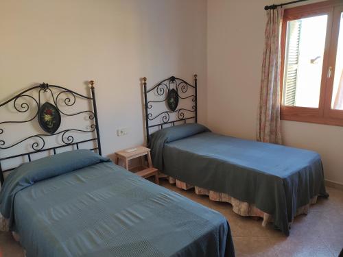 um quarto com 2 camas e uma janela em Casa familiar con piscina, cerca de la playa em Ciutadella