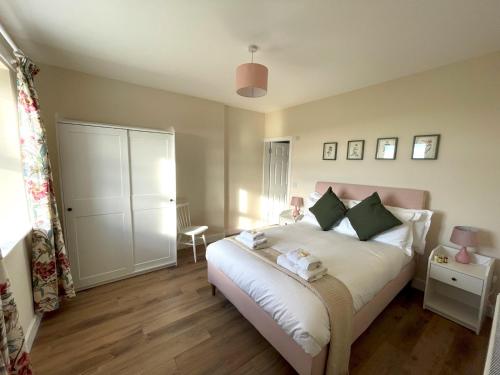 a bedroom with a large white bed and a table at Pass the Keys Beautiful 5BR Rural Cottage with Outstanding Views in Castle Douglas