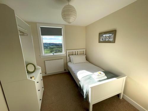 a small bedroom with a bed and a window at Pass the Keys Beautiful 5BR Rural Cottage with Outstanding Views in Castle Douglas