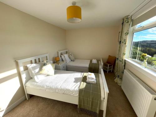 1 dormitorio con 2 camas y ventana en Pass the Keys Beautiful 5BR Rural Cottage with Outstanding Views en Castle Douglas