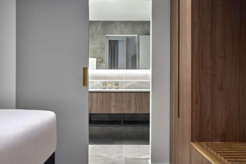 La salle de bains est pourvue d'un lavabo et d'un miroir. dans l'établissement Adina Apartment Hotel Melbourne, Pentridge, à Melbourne