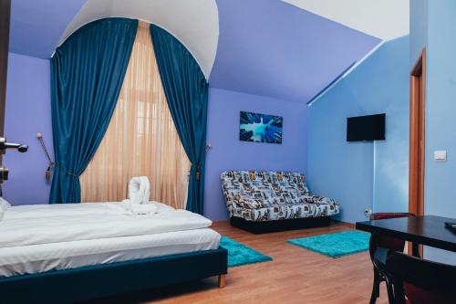 a bedroom with blue walls and a bed and a table at GUITAR - Camere de Inchiriat in Sibiu