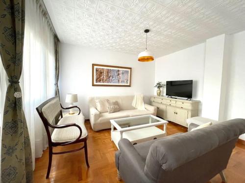 - un salon avec un canapé et une table dans l'établissement 167A La Costa de mis amores, à Gijón
