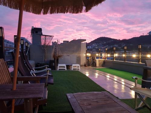 a rooftop patio with a view of the city at dusk at Leehakjang guesthouse in Mokpo