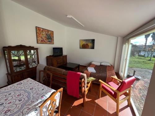 a room with a bed and a table and chairs at Casa da Cabração - Refúgio de Natureza e Sossego in Ponte de Lima