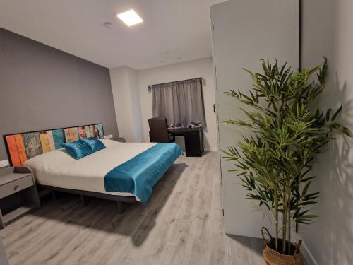a bedroom with a bed and a potted plant at Malasaña Dreams S,L in Madrid