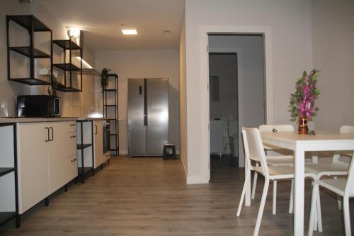 a kitchen and dining room with a table and a refrigerator at Malasaña Dreams S,L in Madrid