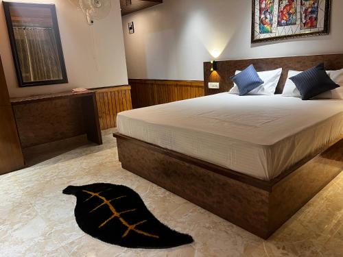 a bedroom with a large bed and a black blanket on the floor at Calm Paradise in Shimla