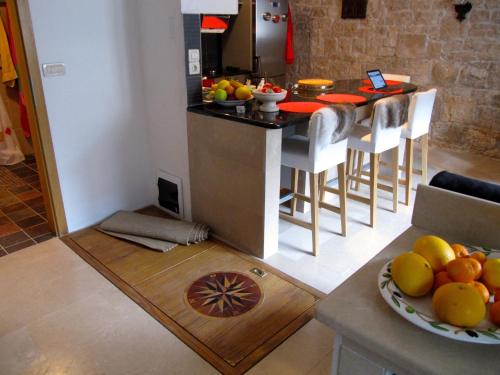 Una cocina con una mesa con un bol de fruta en el suelo. en Pearl of Povlja, en Povlja