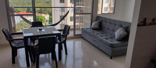sala de estar con mesa y sofá en Cómodo Apartamento, Hacienda Peñaliza - Ricaurte, en Ricaurte