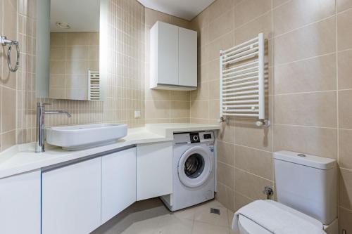 a bathroom with a washing machine and a sink at Charming Flat with Gorgeous City View in Atasehir in Istanbul
