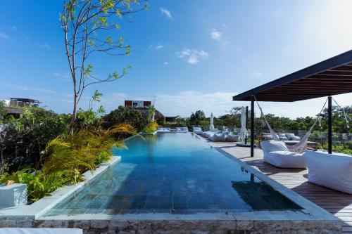 a pool at the resort with lounge chairs at Divine 1BR PH with Private Pool and Spectacular Pools in Tulum