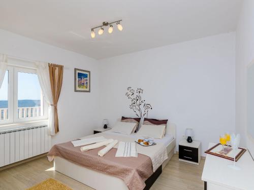 Un dormitorio blanco con una cama grande y una ventana en Luxurious Villa in Gruda with Pool, en Nartiće
