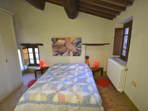 Un dormitorio con una cama y un cuadro en la pared. en In a wonderful medieval village on the Tuscan hills, with air conditioning, en Montecastelli