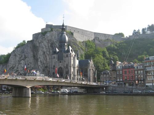 a bridge over a river in front of a mountain at Charming Mill in Gedinne in Vencimont