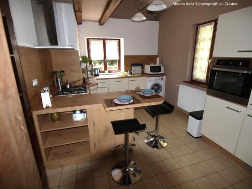 a kitchen with a counter and two stools in it at Forest Retreat in Vosges in Hanviller