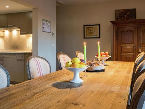 a dining room table with two bowls of fruit and candles at Cozy Holiday Home in Gedinne near Forest in Vencimont