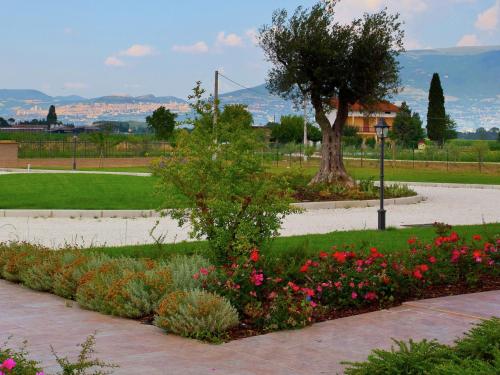a garden with flowers and a tree in a park at Romantic Countryside Escape in Tordandrea