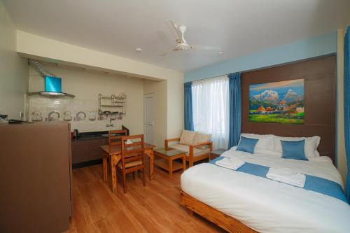 a bedroom with a large bed and a kitchen at Lotus Apartment in Pokhara