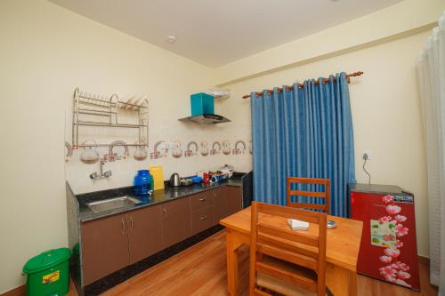 a kitchen with a table and a blue curtain at Lotus Apartment in Pokhara