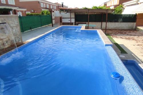 a swimming pool with blue water in a backyard at La Casa de Taramona, cerca de Puy Du Fou in Barcience