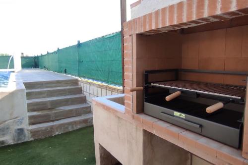 a barbecue on the side of a building with stairs at La Casa de Taramona in Barcience