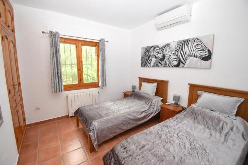 1 dormitorio con 2 camas y una foto de cebras en Casa Delfin, en Jávea