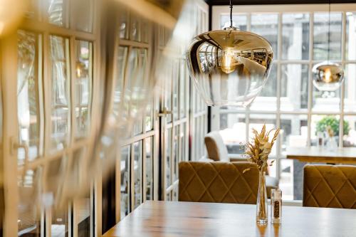 a dining room with a table and a chandelier at Privathotel alte mühle Wolfsburg-Weyhausen in Wolfsburg