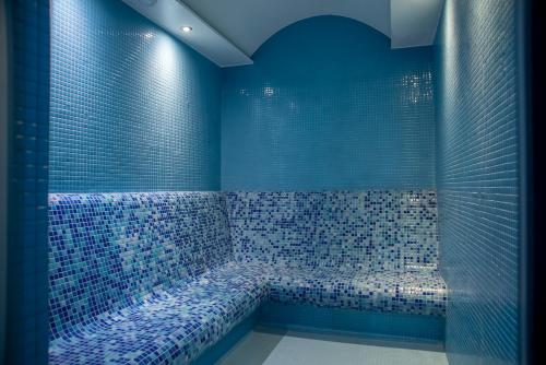 Midyat Royal Hotel & Spa في مِديات: حمام ازرق مع حوض مع بلاط ازرق
