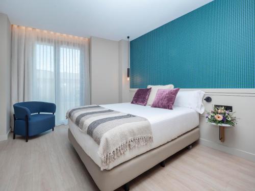 um quarto com uma cama grande e uma parede azul em ARCELON HOTEL - New from 2023 em Barcelona