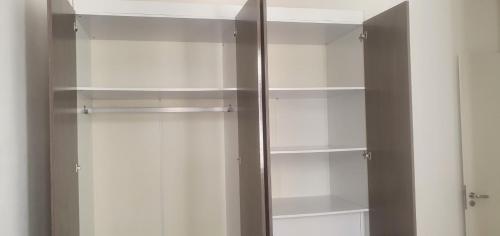 a glass cabinet with white shelves in a room at Apartamento Bem Viver in Salvador