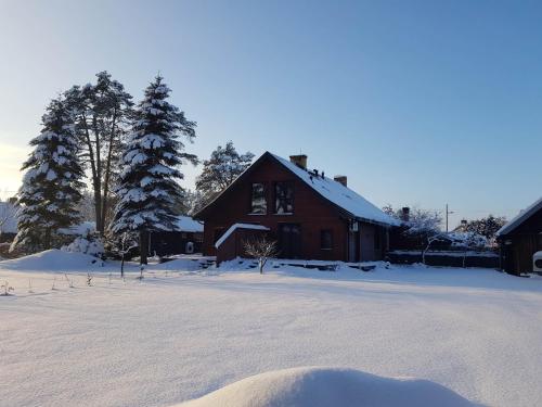 a house with snow on the ground in front of it at Dom Płociczno-Osiedle koło Suwałk in Płociczno
