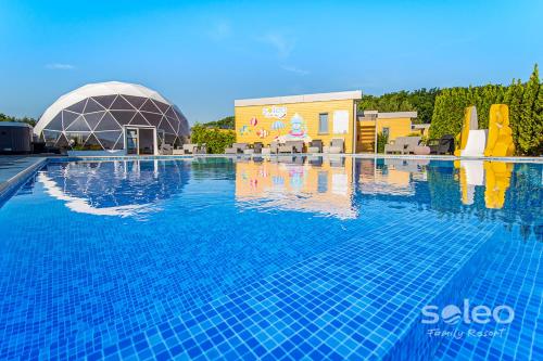 uma grande piscina com um edifício e um resort em Apartament Dwupoziomowy SUPERIOR z 2-sypialniami i klimatyzacją - SOLEO Family Resort em Rewal