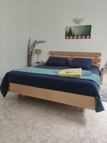 a bedroom with a bed with blue pillows at Maderalzinho in Mindelo